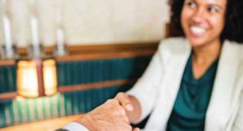 Person shaking hands during meeting.